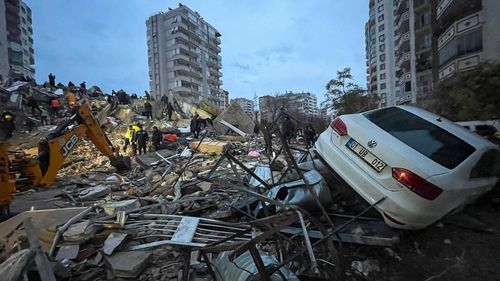 Emergency teams search for people in a destroyed building in Adana, Turkey, Monday, Feb. 6, 2023. 