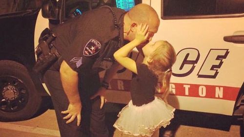 Police officer kissing his daughter gives human face to law enforcement