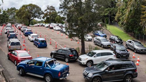 Cars wait at Roselands Shopping Centre COVID-19 clinic.