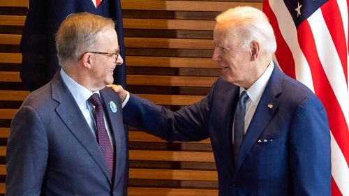 US President Joe Biden greets Anthony Albanese with a hand on his shoulder and a warm smile.
