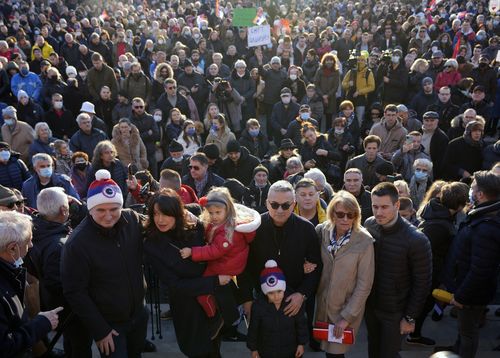 Novak Djokovic's father Srdjan, front centre, mother Dijana, second right, and brother Djordje, right, pose after protest in Belgrade, Serbia, Friday, Jan. 7, 2022.