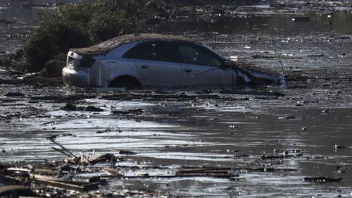 A car sits in flooded water. (Image: AAP)