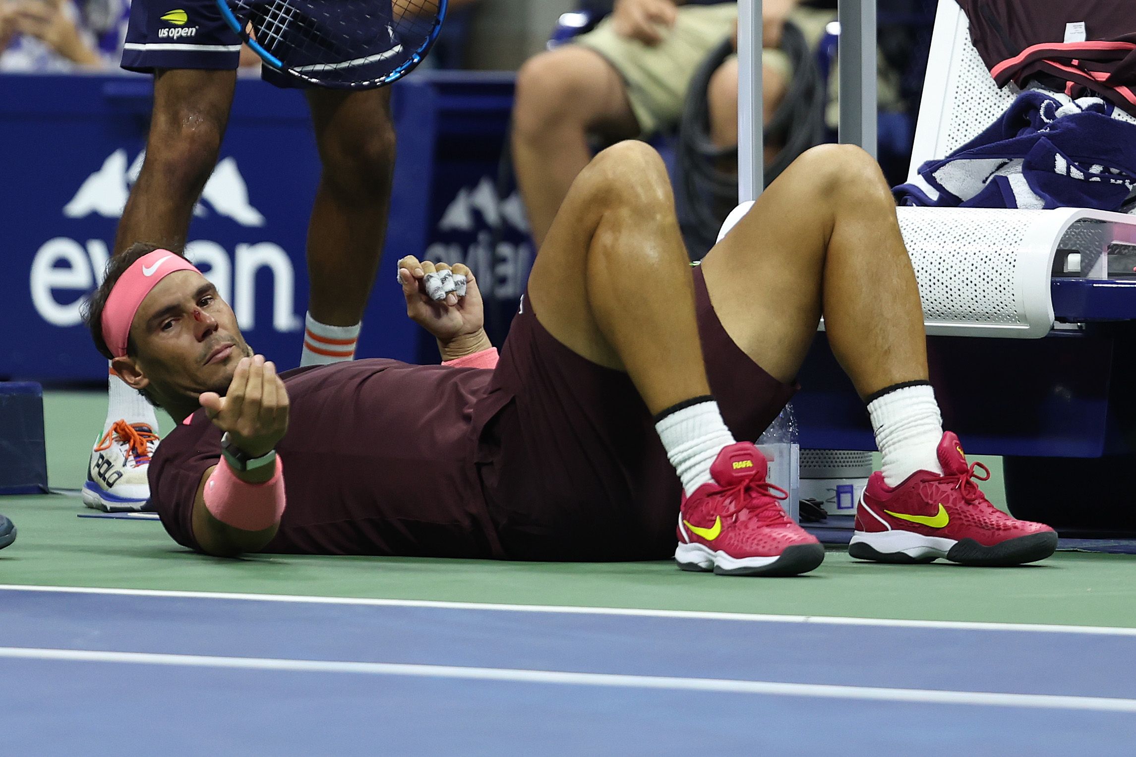 Rafael Nadal of Spain lies on the ground after accidentally hitting himself in the head.