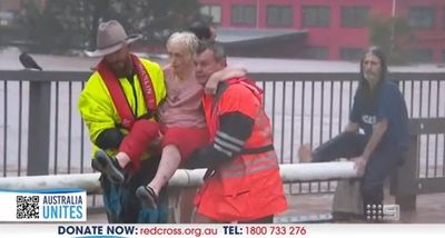 Rescue workers help elderly woman trapped in floods