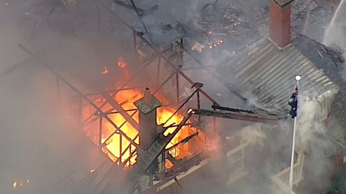 Flames have burned through the roof of the building. (9NEWS)