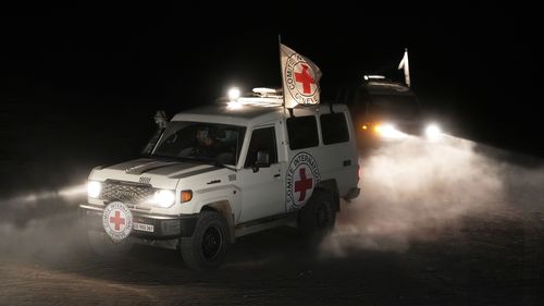 Red Cross vehicles carrying the bodies of three people believed to be deceased Israeli hostages handed over by Hamas