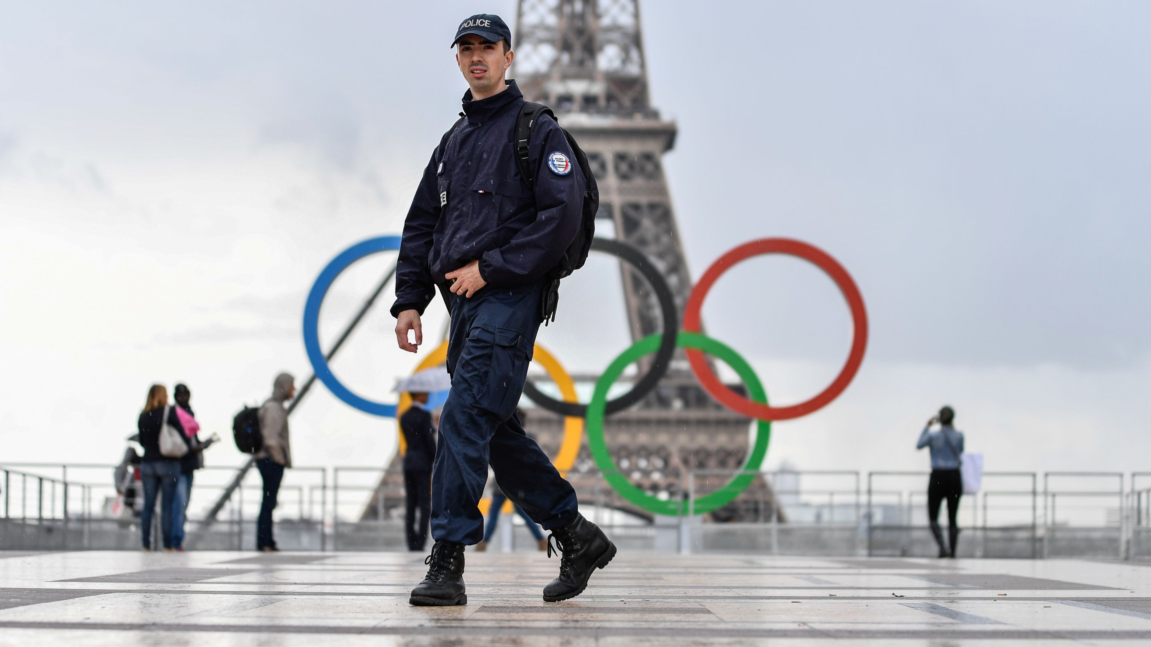 A policeman walks in front of the Eiffel Tower in Paris.