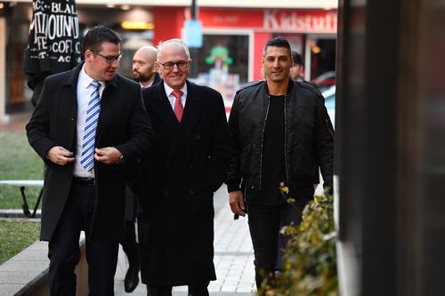 Prime Minister Malcolm Turnbull arrives at a cafe in Manuka, Canberra, this morning with Assistant Minister for Science Zed Seselja. Picture: AAP