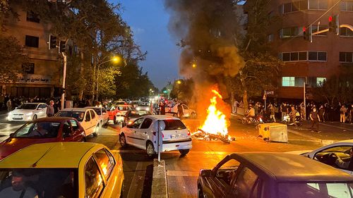 A police motorcycle burns during a protest over the death of Mahsa Amini, a woman who died after being arrested by the Islamic republic's "morality police", in Tehran, Iran September 19, 2022.  