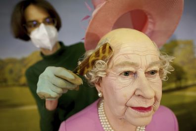 The wax figure of Queen Elizabeth II is bald underneath her hat.