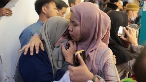 A woman is comforted as she weeps while rescue work is underway after a building collapsed at an Islamic boarding school in Sidoarjo, East Java, Indonesia, Monday, Sept. 29, 2025. (AP Photo/Trisnadi)