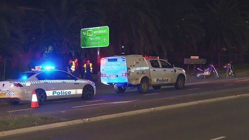Police are searching for the driver of a white Mazda involved in an alleged road rage attack in western Sydney that has left a motorcycle rider seriously injured