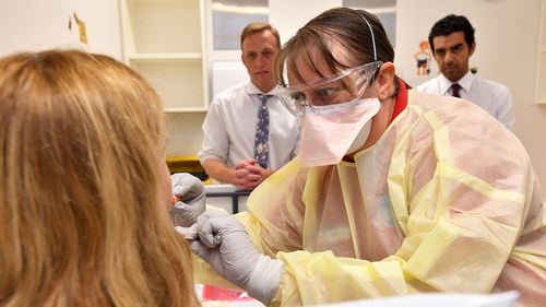A GP performs a mock coronavirus examination on a patient inside the fever clinic at the Prince Charles Hospital in Brisbane.