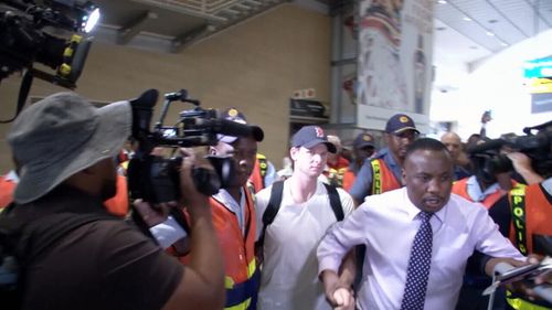 Smith is booed as he is escorted through Johannesburg Airport.