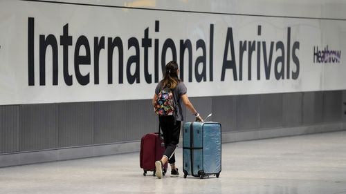 A passenger arrives from a flight at Terminal 5 of Heathrow Airport in London, Monday, August 2, 2021. 