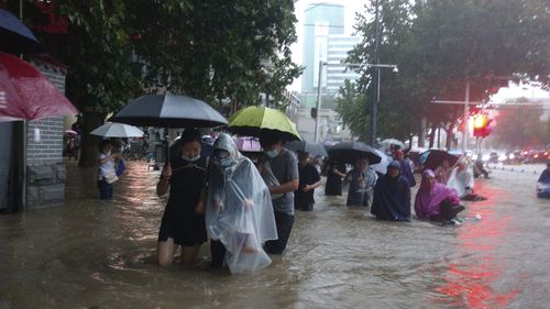 People move through flood water after a heavy downpour in Zhengzhou city, central China's Henan province.