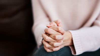 Cropped shot of a woman sitting on a sofa and feeling anxious