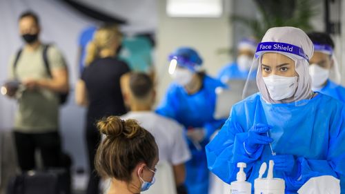 SYDNEY, AUSTRALIA - DECEMBER 23: A health worker looks on at the Histopath pre-departure COVID testing clinic at Sydney International airport on December 23, 2021 in Sydney, Australia. Demand at COVID-19 testing centres across Sydney has increased in the lead up to Christmas as NSW coronavirus case numbers rise. People travelling to Queensland, Tasmania and South Australia are required to show a negative PCR test to enter those states while Western Australia's borders are closed to NSW traveller