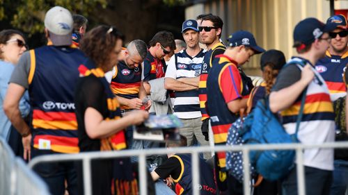 Crows and Cats fans line up to enter the stadium before the Adelaide Crows and Geelong Cats Men's AFL First Preliminary Final at the Adelaide Oval in Adelaide. (AAP)