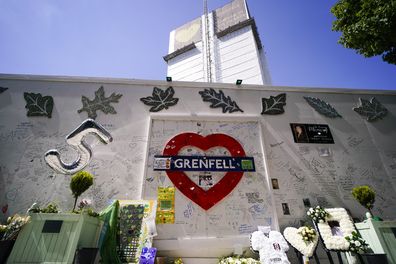 Flowers and tributes left outside the remains of the Grenfell Tower, in London, Tuesday, June 14, 2022. 