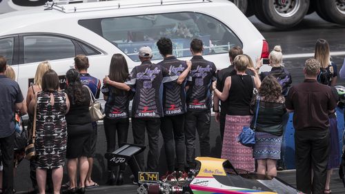 Morners watch the hearse carrying Anita's coffin make a trip down the drag-strip at the Perth Motorplex. (AAP)