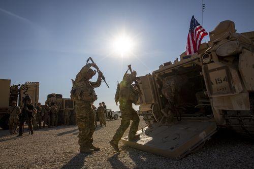 FILE - Crewmen enter Bradley fighting vehicles at a US military base at an undisclosed location in Northeastern Syria, on Nov. 11, 2019. Legislation directing President Joe Biden to remove some 900 U.S. troops from Syria within 180 days was soundly defeated in the House on Wednesday, March 8, 2023, as opponents of the measure warned that it could allow a dismantled Islamic State group to reorganize and endanger the U.S. and its allies. (AP Photo/Darko Bandic, File)