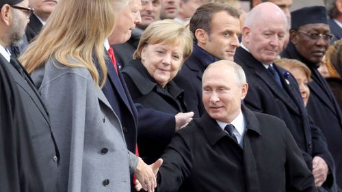 Russian President Vladimir Putin shakes hands with US First Lady Melania Trump as he arrives at the Paris ceremony.