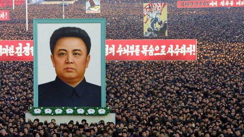 North Koreans hold a massive portrait of Kim Jong-il. (AAP)