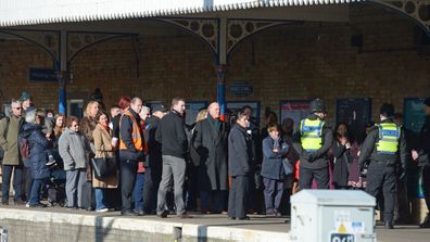 Passengers are held back by police officers as Queen Elizabeth II boards a train at King's Lynn railway station in Norfolk, as she returns to London after spending the Christmas period at Sandringham House in north Norfolk