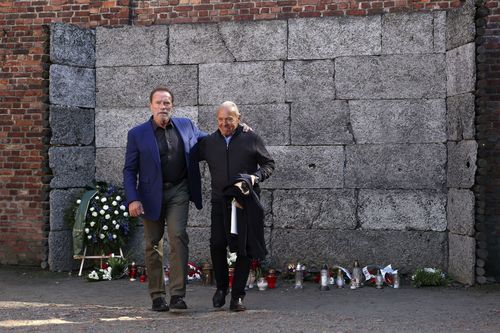 Arnold Schwarzenegger, left, and Simon Bergson, chairman of The Auschwitz Jewish Center Foundation, walk in front of wall of death in Auschwitz - Birkenau Nazi German death camp in Oswiecim, Poland, Wednesday, Sept. 28, 2022. 