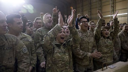 Members of the military cheer as President Donald Trump speaks at a hangar rally at Al Asad Air Base, Iraq.