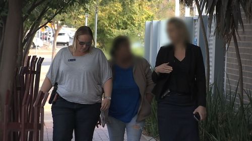 A government worker (left) escorts a woman facing court for the child abuse (middle) and her legal representative. (NSW Police)