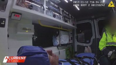 Andrew John Cobby seen in police body camera video inside an ambulance. 