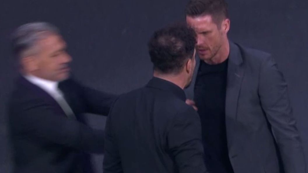 Diego Simeone squares up to Sebastian Kehl on the sidelines.