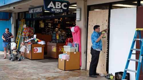 Business owners and residents board up their buildings.