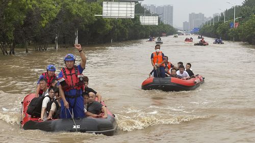 Residents are evacuated by rubber boats through flood waters in Zhuozhou in northern China's Hebei province, south of Beijing on Wednesday.