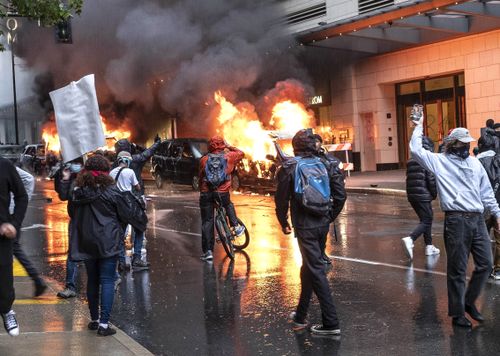 People set fire to vehicles during a protest in Seattle.