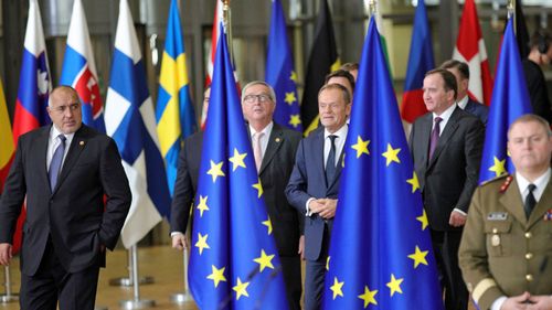 European Council President Donald Tusk, center right, and European Commission President Jean-Claude Juncker, center left, arrive for a group photo at an EU summit at the Europa building in Brussels. (AAP)