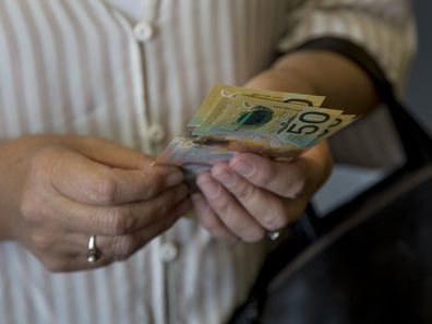 Woman holding Australian cash.