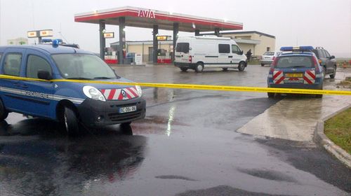 Police close off a service station in northern France where the fugitive gunmen were reportedly spotted.