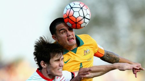 Tim Cahill competes for the ball with Eraj Rajabov of Tajikistan.