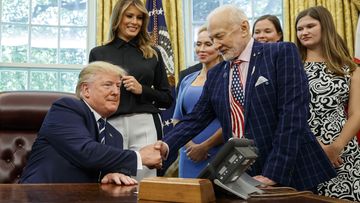 President Donald Trump shakes hands with Apollo 11 astronaut Buzz Aldrin, with first lady Melania Trump.