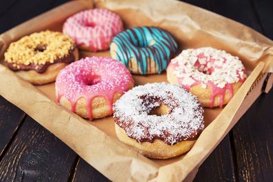 A box with fresh homemade donuts with icing.