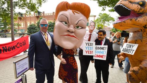Protesters wearing masks depicting One Nation leader Pauline Hanson, Prime Minister Malcolm Turnbull and Gautam Adani are seen with a person in a dinosaur costume depicting former Prime Minister Tony Abbott outside the Queensland LNP (Liberal National Party) state convention in Brisbane in July 2018. Picture: AAP