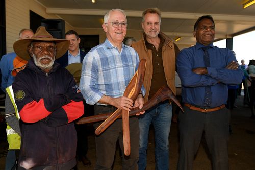 Mr Turnbull looks on after being presented gifts with traditional owner Dick Foster (left), Indigenous Affairs Minister Nigel Scullion and traditional owner Ronald Plummer. Picture: AAP