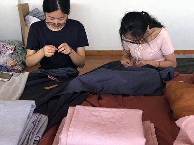 Workers hard at work on one of Sheet Society's linen collections.