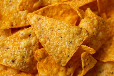 Crispy corn chips, triangular-shaped nachos with a cheese flavor. Fast food close-up