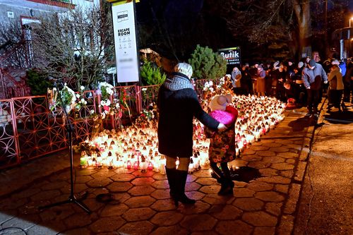 Mourners light candles at the scene of the tragedy.