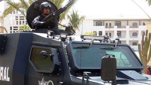 A heavily armed policeman keeps watch in Los Cabos, Mexico. (AAP)