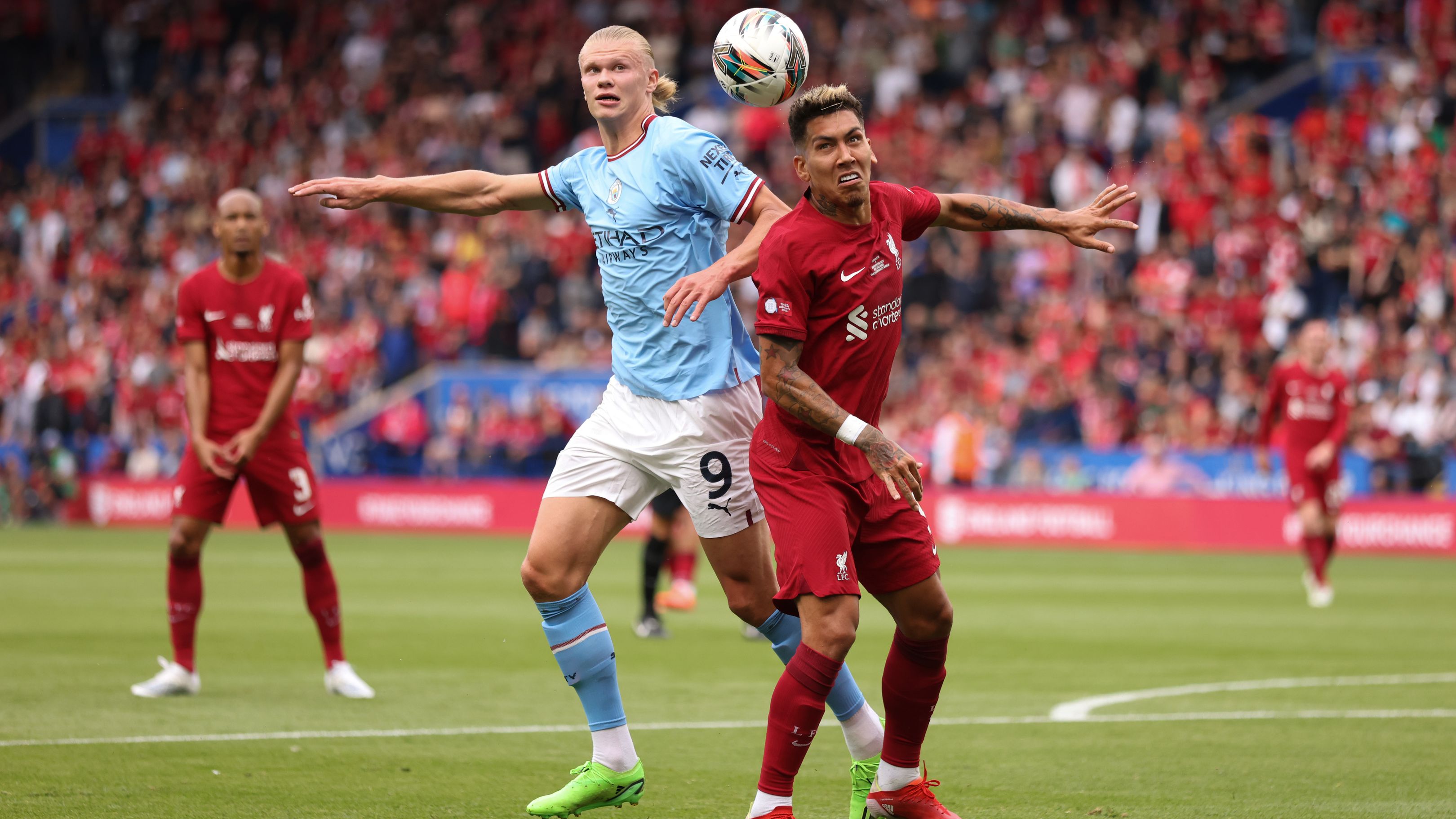 Erling Haaland of Manchester City in action with Roberto Firmino of Liverpool.